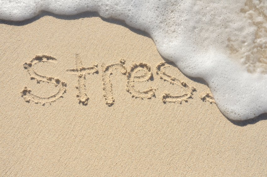 Releiving Stress, the Word Stress Being Washed Away by a Wave on a Beach